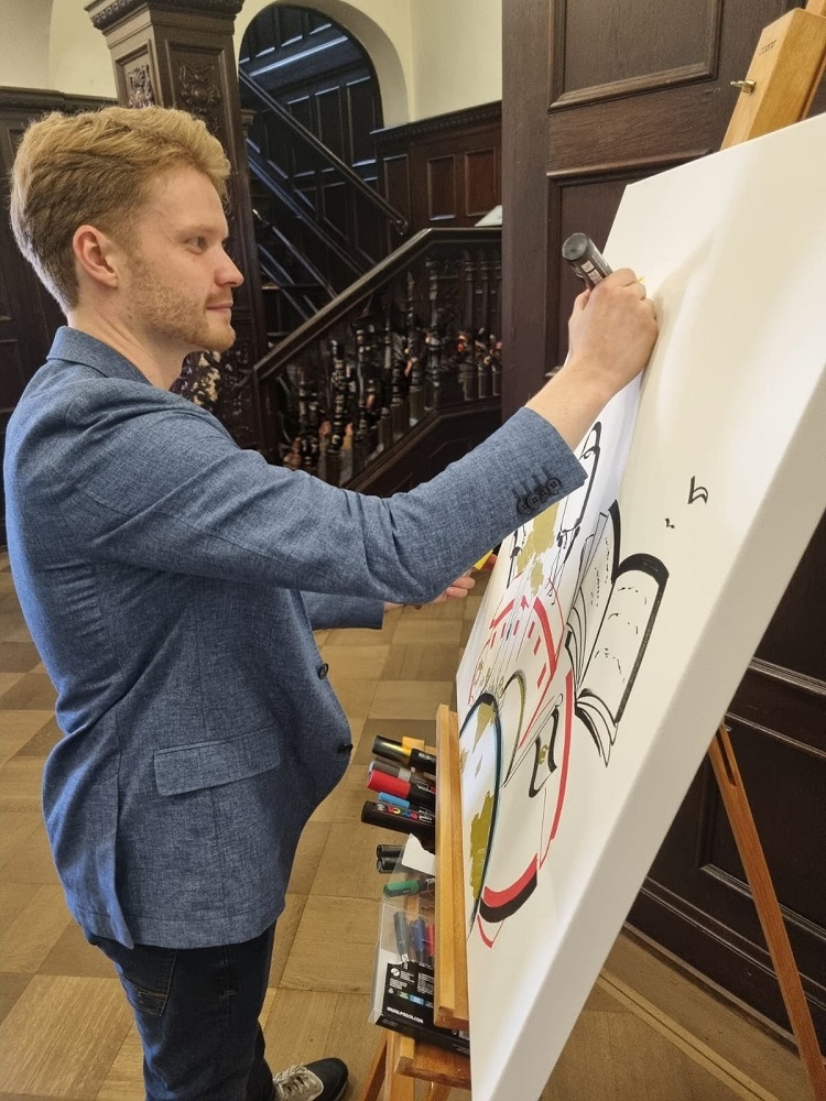 Foto: Lukas Pütz vor einer Leinwand