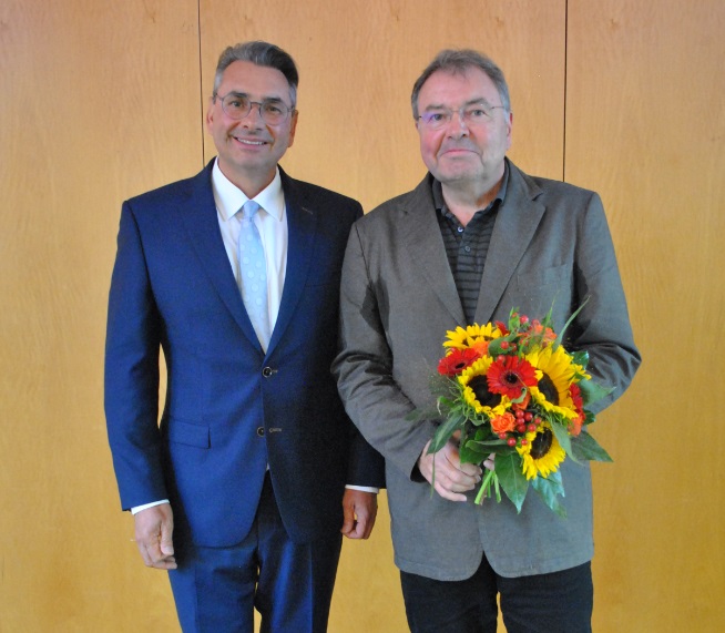 Foto: Bürgermeister Dr. Berger und Jörg Adomat mit Blumenstrauß