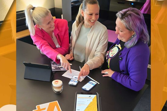 drei Frauen in einem Büro mit Tablet Handy und Kaffee
