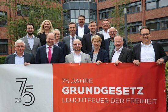 Die Bürgermeisterinnen und Bürgermeister mit einem Banner "75 Jahre Grundgesetz"