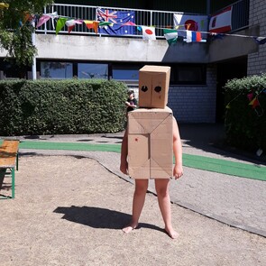 Foto: Kind als Roboter mit Kartons angezogen