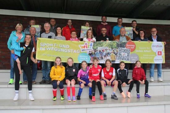 Gruppenbild mit Banner auf Tribüne