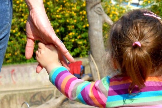 Foto: Mädchen wird an der Hand gehalten