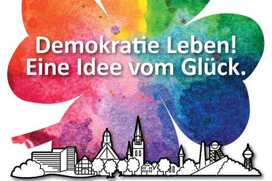 Logo: Demokratie leben - eine Idee vom Glück in einem farbigen Kleeblatt