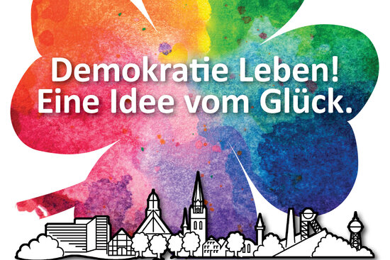 Logo: Demokratie leben - eine Idee vom Glück in einem farbigen Kleeblatt