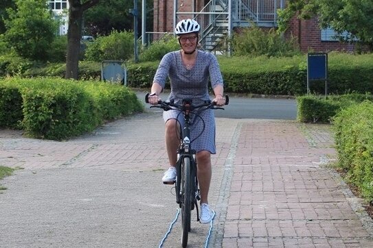 Foto: Frau mit Helm auf einem Fahrrad